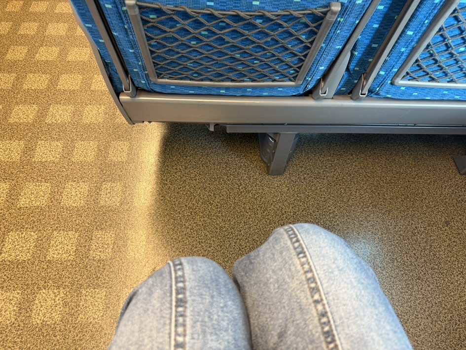 You'll need to keep your luggage clear of the aisle and fit your suitcase in front of your knees